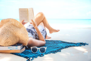 Woman reading on the beach by Canva | summer book club | marinalife